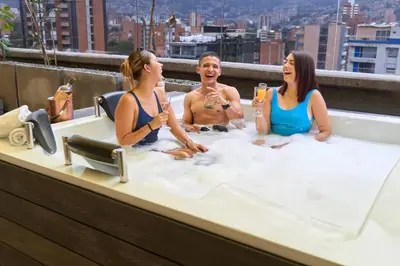 a group of three people sitting in a bathtub at Charming Aparta-Suite Stadio Rosa Negra Retreat in Medellín