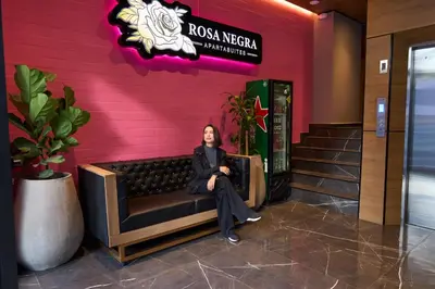 a woman sitting on a bench in the lobby of a hotel at Charming Aparta-Suite Stadio Rosa Negra Retreat in Medellín