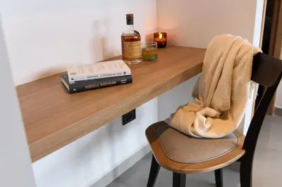 a wooden table with a bottle of whiskey and a chair at Cozy Aparta-Suite Stadio Jacuzzi Rosa Negra in Medellín
