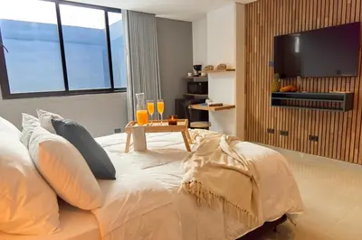 a bedroom with a bed and a table with glasses on it at Rosa Negra Haven Cozy Stadio Aparta-Suite in Medellín