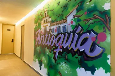 a wall in a hallway with a mural of a tree at Comfortable Stadio Suite Rosa Negra in Medellín