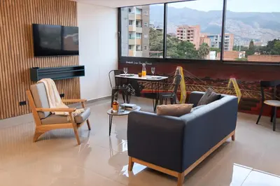 a living room with a couch and a table at Comfortable Stadio Suite Rosa Negra in Medellín