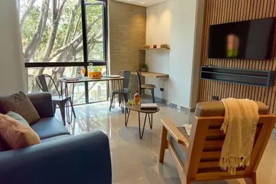 a living room with a couch and a table at Rosa Negra Comfort Stadio Aparta-Suite in Medellín