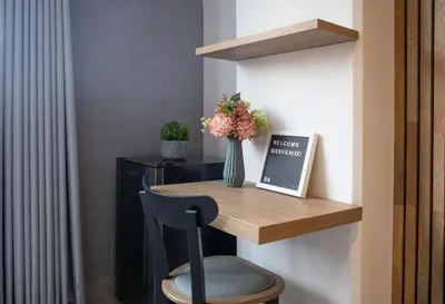 a desk with a chair and a vase of flowers at Stadio Serenity Rosa Negra Aparta-Suite in Medellín
