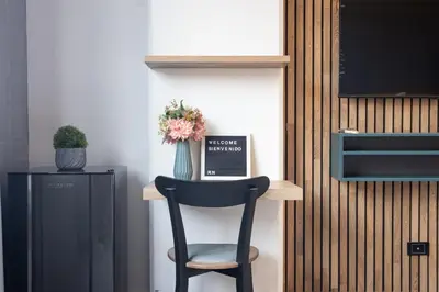 a black chair sitting on a shelf with a vase of flowers at Stadio Serenity Rosa Negra Aparta-Suite in Medellín
