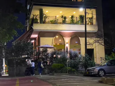 a building with people walking in front of it at night at Elegant Cozy Suite Rosa Negra Stadio in Medellín