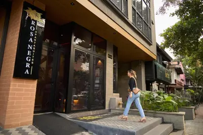 a woman walking in front of a building at Cozy Comfort at Rosa Negra Stadio Suite in Medellín