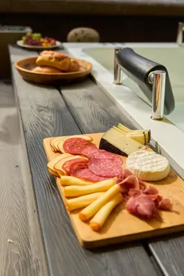 a cutting board with meats and cheese on a counter at Cozy Comfort at Rosa Negra Stadio Suite in Medellín