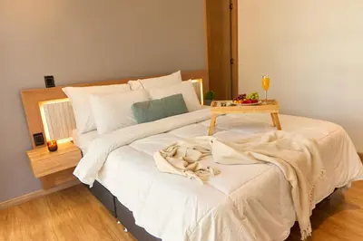 a bedroom with a bed with a table on it at Cozy Comfort at Rosa Negra Stadio Suite in Medellín