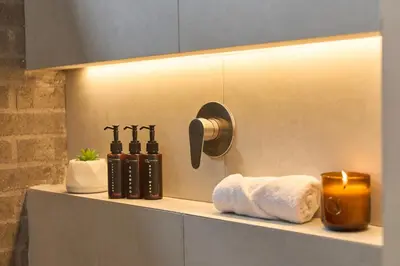 a bathroom with a shelf with towels and a candle at Jacuzzi Retreat Cozy Aparta-Suite Rosa Negra in Medellín