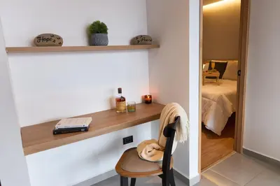 a room with a desk and a chair and a bedroom at Jacuzzi Retreat Cozy Aparta-Suite Rosa Negra in Medellín