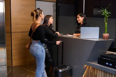 three women standing at a counter in an office at Jacuzzi Retreat Cozy Aparta-Suite Rosa Negra in Medellín