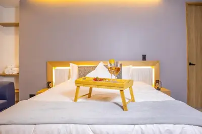 a tray of fruit on a bed with a table at Chic and Cozy Stadio Suite Rosa Negra in Medellín