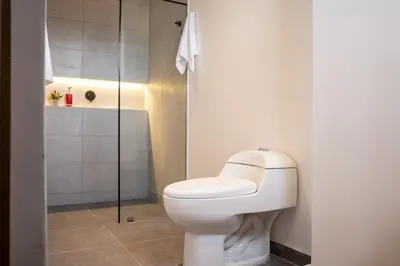 a bathroom with a toilet and a shower at Chic and Cozy Stadio Suite Rosa Negra in Medellín