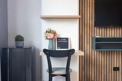 a black chair sitting on a shelf with a vase of flowers at Chic and Cozy Stadio Suite Rosa Negra in Medellín