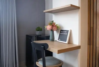 a desk with a vase of flowers and a chair at Chic and Cozy Stadio Suite Rosa Negra in Medellín