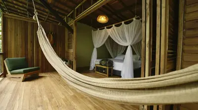a hammock in a bedroom with a bed at Montés Samaná in San Carlos