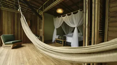 a hammock in a bedroom with a bed at Montés Samaná in San Carlos