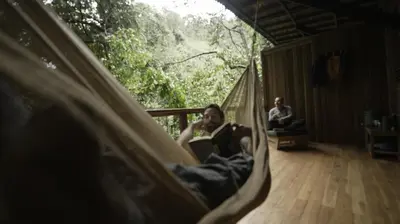 a man laying in a hammock in a room at Montés Samaná in San Carlos