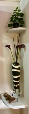 a black and white vase with a plant on a shelf at Acogedor y Cómodo Estadio Laureles in Medellín
