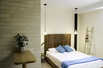 a bedroom with a bed and a potted plant at Yarumo in Medellín