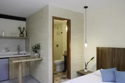 a bathroom with a bed and a sink and a toilet at Yarumo in Medellín