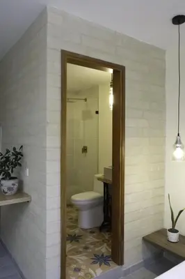a bathroom with a toilet and a glass shower at Yarumo in Medellín