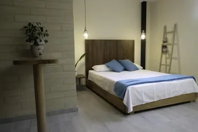 a bedroom with a bed with blue pillows and a table at Yarumo in Medellín