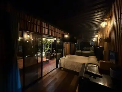 a bedroom with a bed and a living room at Tierra Escondida Glamping in Barbosa