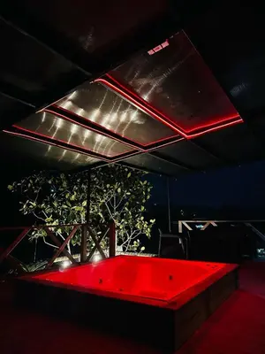 a black room with a red table with a plant at Tierra Escondida Glamping in Barbosa