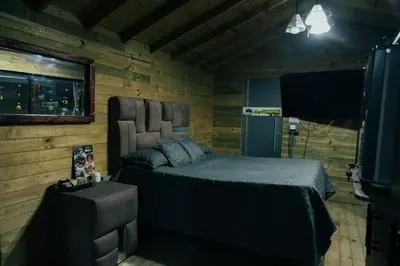 a bedroom with a bed in a log cabin at Tierra Escondida Glamping in Barbosa