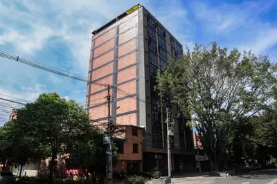 a tall building on the corner of a street at Rosa Negra's Cozy Stadio Haven in Medellín