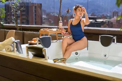 a woman in a bathing suit sitting in a bath tub at Rosa Negra's Cozy Stadio Haven in Medellín