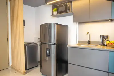a kitchen with a stainless steel refrigerator and a sink at Rosa Negra's Cozy Stadio Haven in Medellín