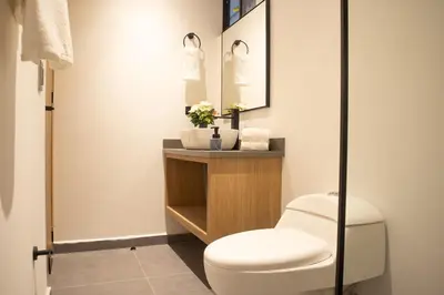 a bathroom with a toilet and a sink at Stadio Serenity Suite | Rosa Negra in Medellín
