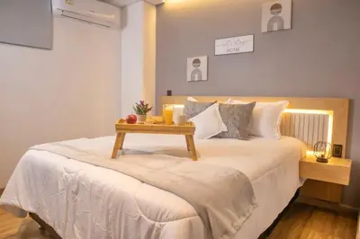 a bedroom with a bed with a table on it at Rosa Negra Suite Near Stadium in Medellín