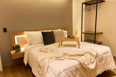 a bedroom with a bed with a table on it at Rosa Negra Suite Near Stadium in Medellín