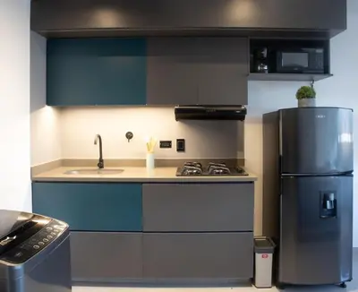 a kitchen with a sink and a refrigerator at Rosa Negra Suite Near Stadium in Medellín