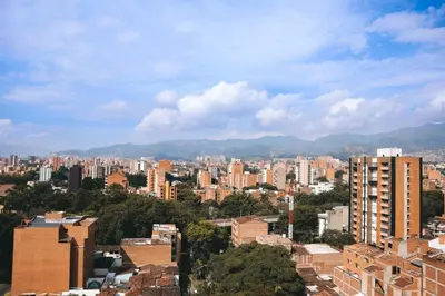 a city with buildings and mountains in the background at Comfortable Escape | Rosa Negra Stadio ApartaSuite in Medellín