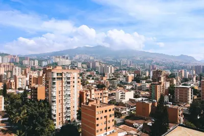 a city with buildings and a mountain in the background at Cozy Getaway | Rosa Negra Stadio Suite in Medellín
