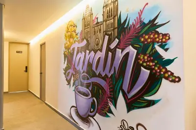 a wall in a hallway with a painting on it at Cozy Getaway | Rosa Negra Stadio Suite in Medellín
