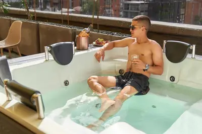 a young man sitting in a hot tub at Cozy Getaway | Rosa Negra Stadio Suite in Medellín