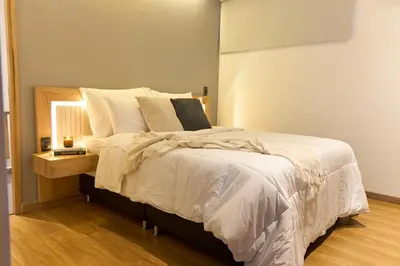 a bedroom with a large bed with white sheets and pillows at Cozy Getaway | Rosa Negra Stadio Suite in Medellín