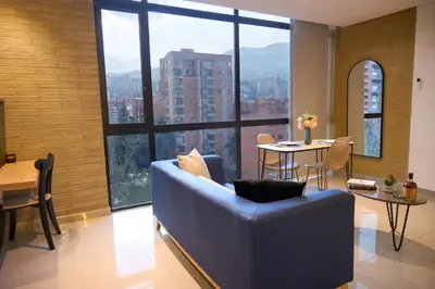 a living room with a blue couch and a table at Warm and Cozy Stadio Suite Rosa Negra in Medellín