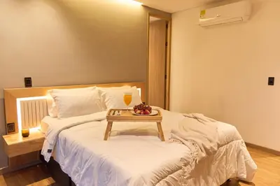 a bedroom with a bed with a table on it at Warm and Cozy Stadio Suite Rosa Negra in Medellín
