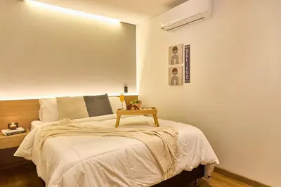 a bedroom with a bed with a table on it at Warm and Cozy Stadio Suite Rosa Negra in Medellín