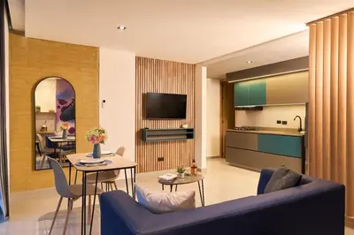 a living room with a blue couch and a kitchen at Warm and Cozy Stadio Suite Rosa Negra in Medellín