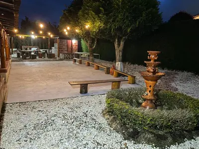 a group of benches and a fountain in a yard at night at Villa Ligia in Medellín