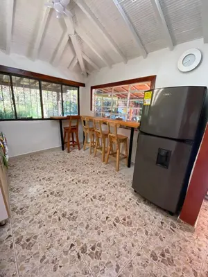 a dining room with a table and a refrigerator at Villa Ligia in Medellín