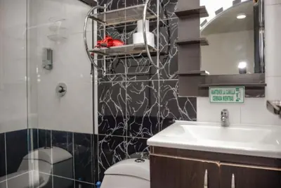 a bathroom with a sink and a toilet and a mirror at Calle 8 101 in Medellín